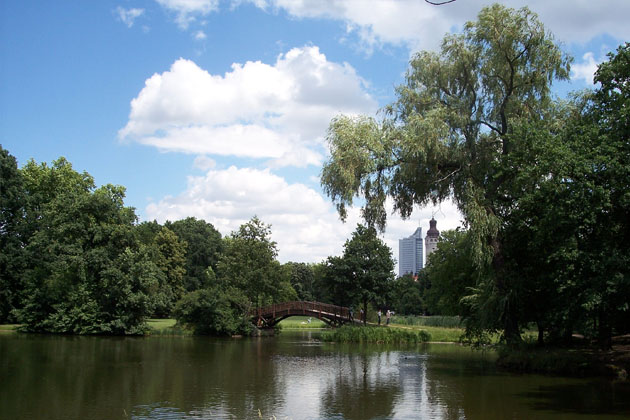 Ein Blick durch den Johannapark in Leipzig auf das Cityhochhaus und den Rathausturm