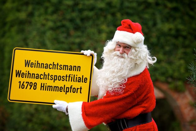 Weihnachtsmann mit Ortsschild Himmelpfort